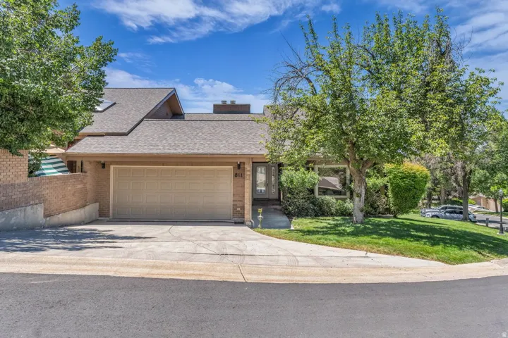 Contemporary residence featuring a two-car garage, brick facade accents, and a front entry with sidelights