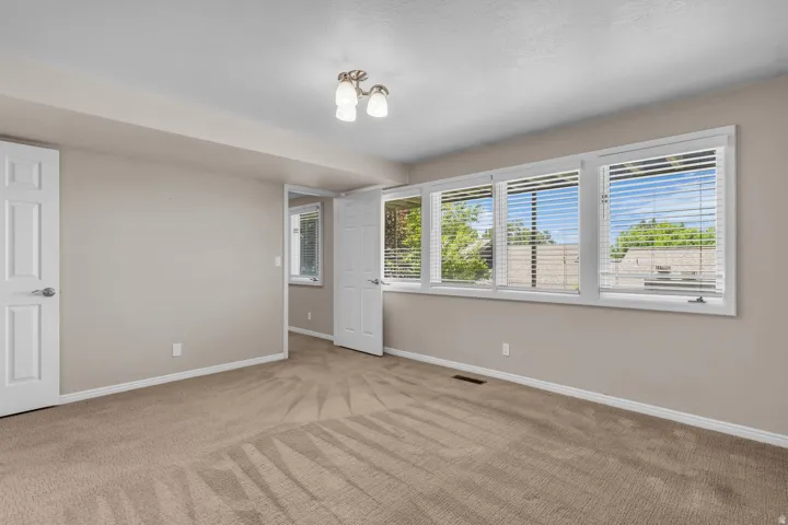 Neutral wall paint with white trim, a multi-pane window configuration with blinds, and recessed lighting