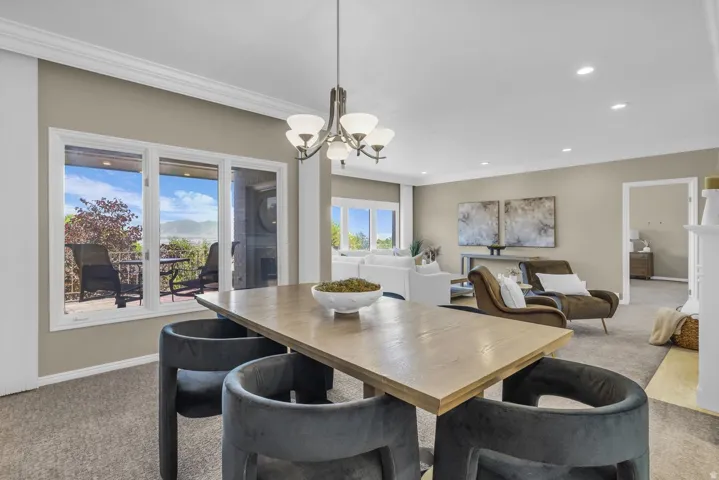 Open-concept living space featuring a wood-finish dining table and a multi-light chandelier