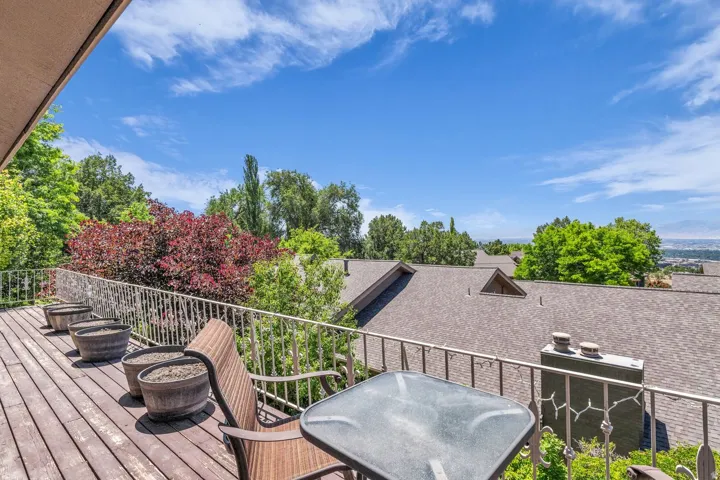 Spacious outdoor deck featuring wood-finish flooring and a metal railing
