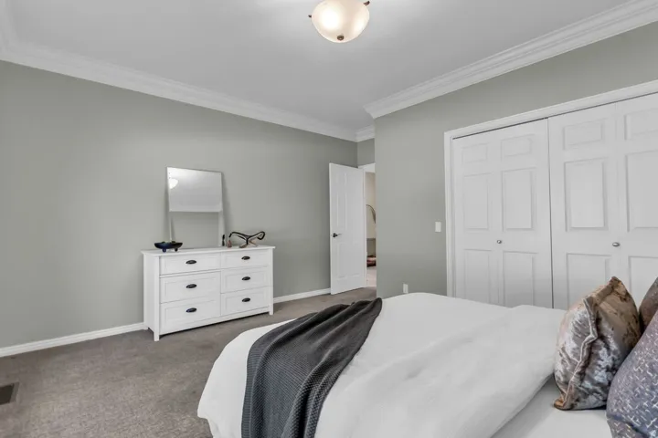 Neutral tone wall paint, crown molding, and plush carpet flooring