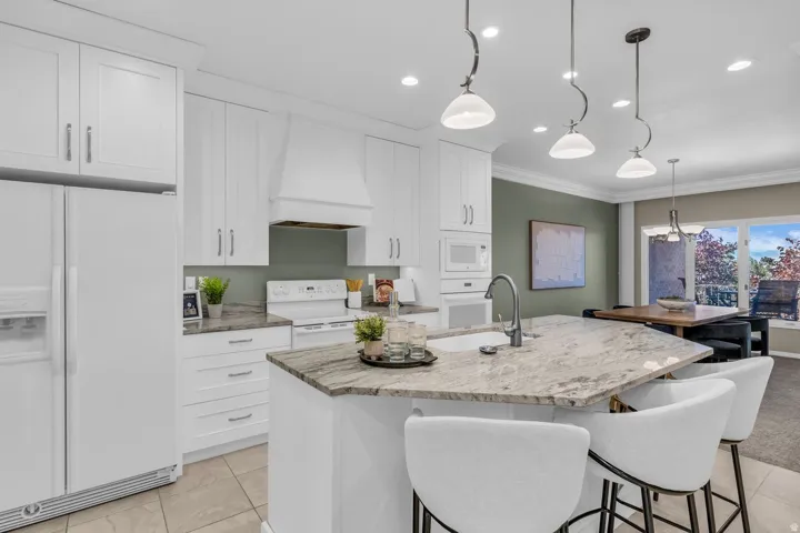 Bright kitchen featuring white cabinetry and appliances