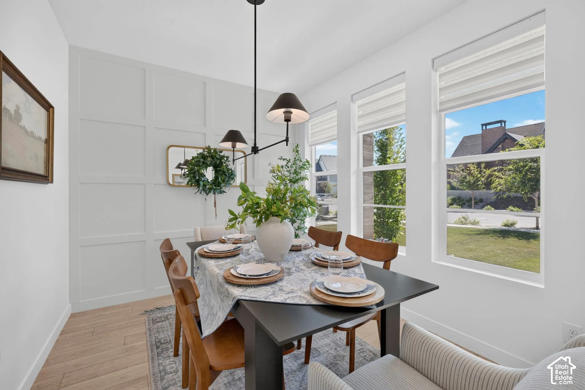 Dining space featuring a decorative accent wall, wood-finish flooring, and a multi-light chandelier