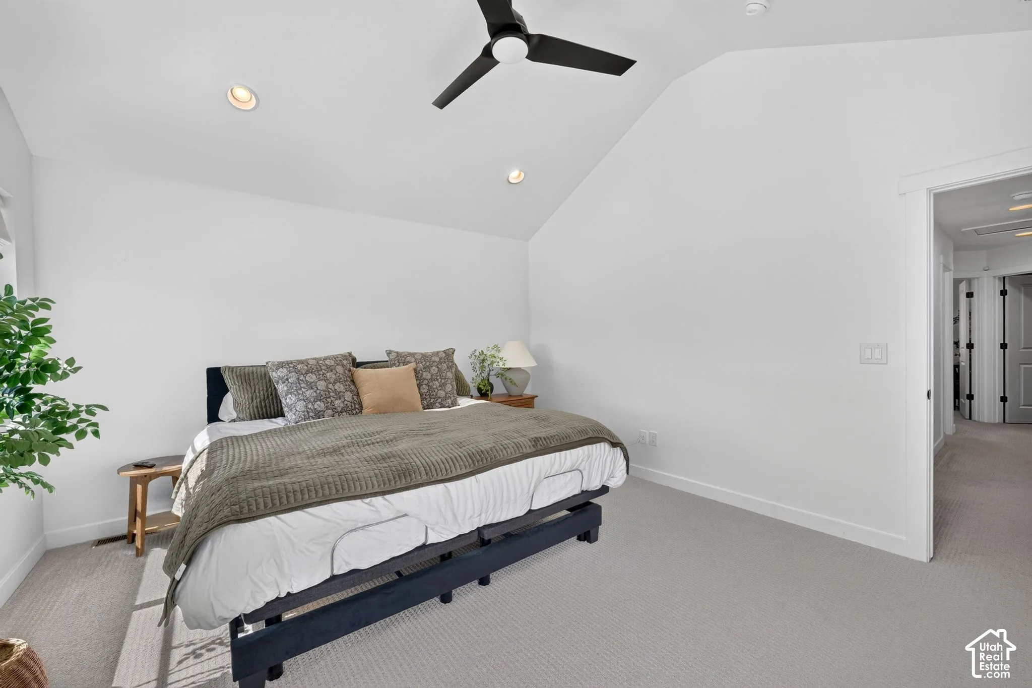 Carpeted bedroom featuring a vaulted ceiling with a ceiling fan, recessed lighting, and a white baseboard trim