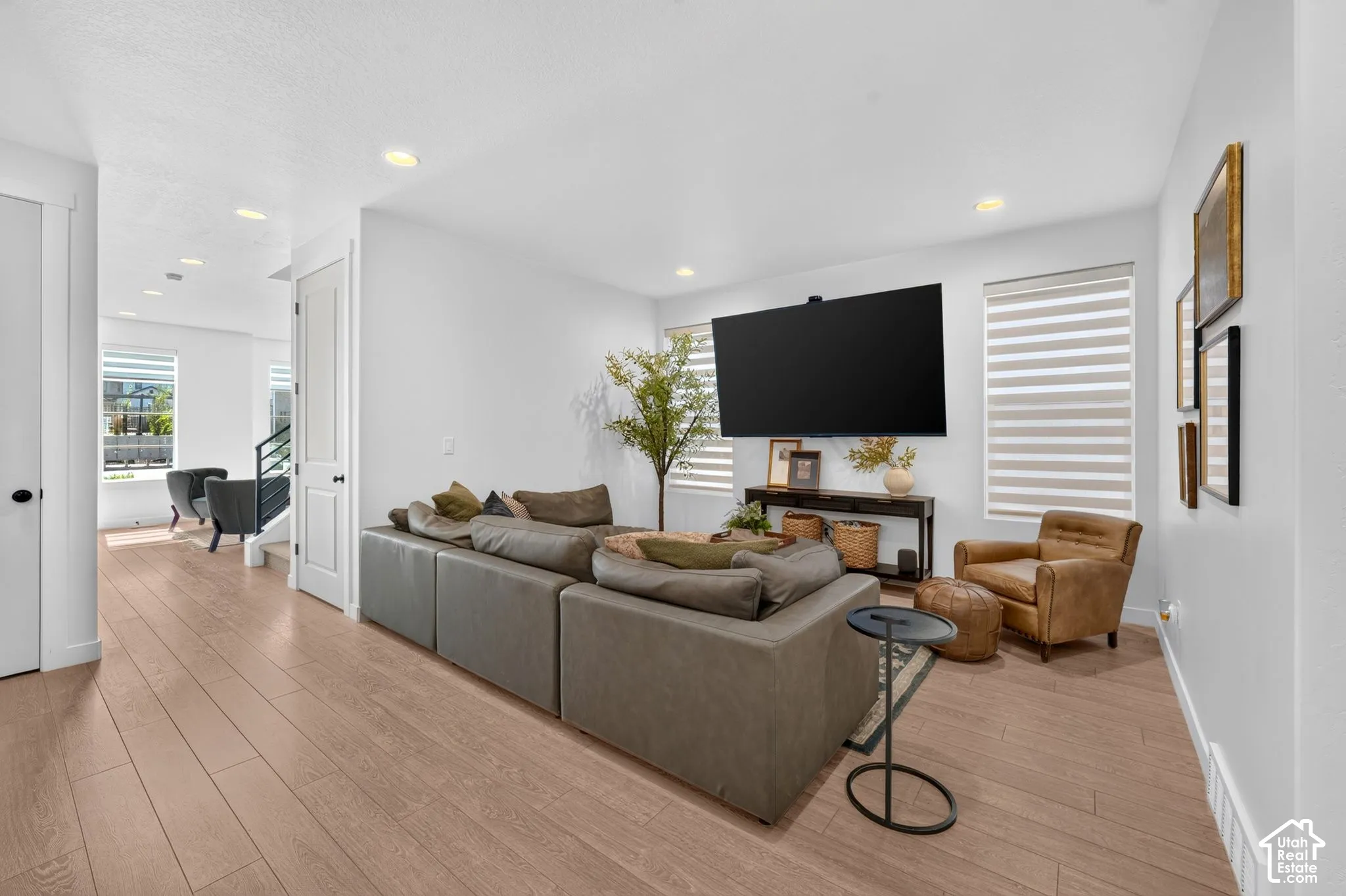 Spacious room with wood-finish flooring, recessed lighting, and white walls