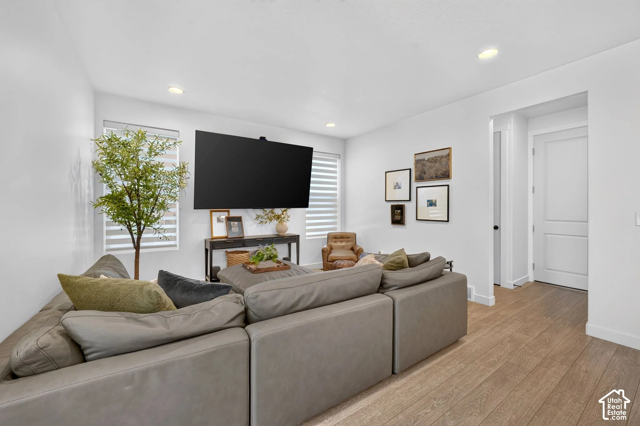 Bright living space featuring wood-finish flooring, recessed lighting, and white walls