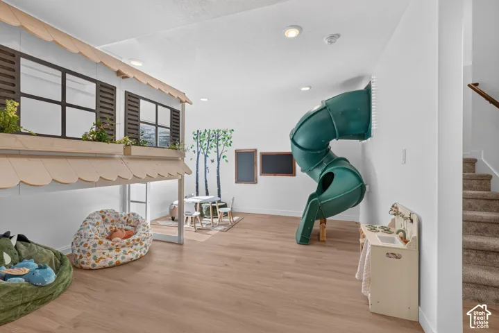 Lower level recreation area featuring light wood-finish flooring