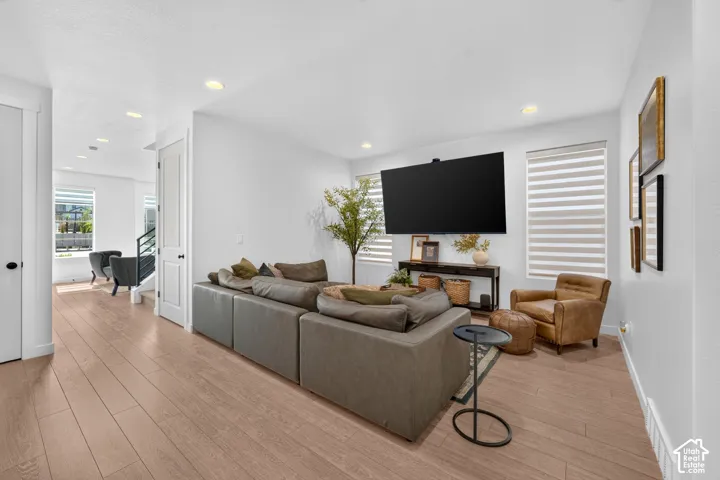 Spacious room with wood-finish flooring, recessed lighting, and white walls