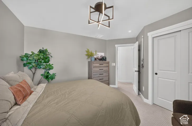 Neutral-toned room featuring a modern geometric ceiling light fixture, light gray walls, and light-colored carpet