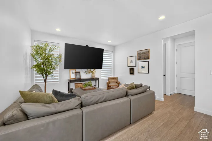 Bright living space featuring wood-finish flooring, recessed lighting, and white walls