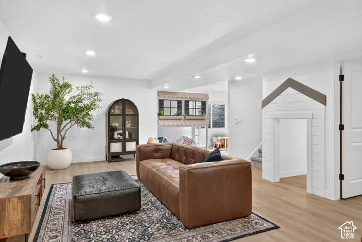 Open-concept living space featuring wood-finish flooring, recessed lighting, and white walls