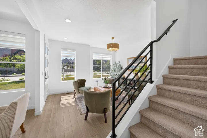 Staircase featuring a black metal railing and carpeted treads