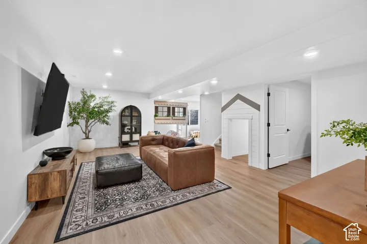 Spacious living area featuring light wood-finish flooring and recessed ceiling lighting