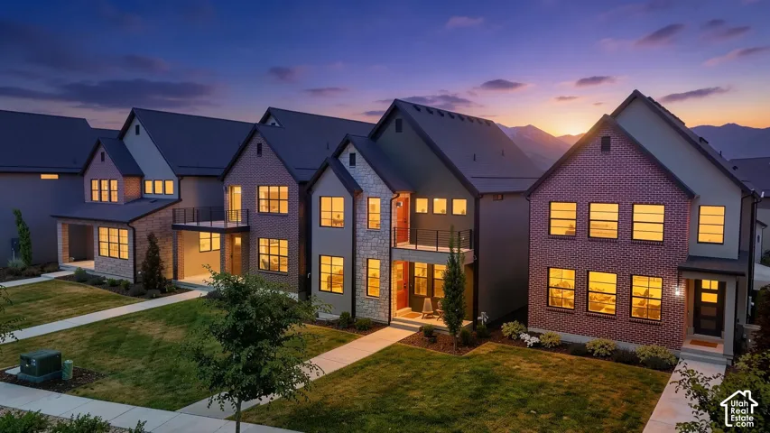 Modern row of residences featuring brick and stone facades, contrasting dark siding, and gabled roofs