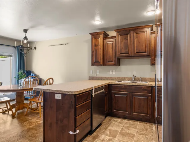 Kitchen featuring dark wood cabinetry, light-toned countertops, and stainless steel appliances