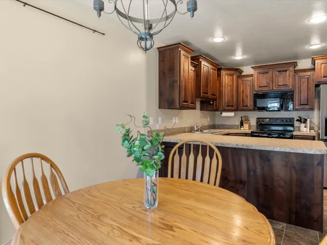 Kitchen featuring wood cabinetry, integrated microwave, black electric range, and light-toned countertops