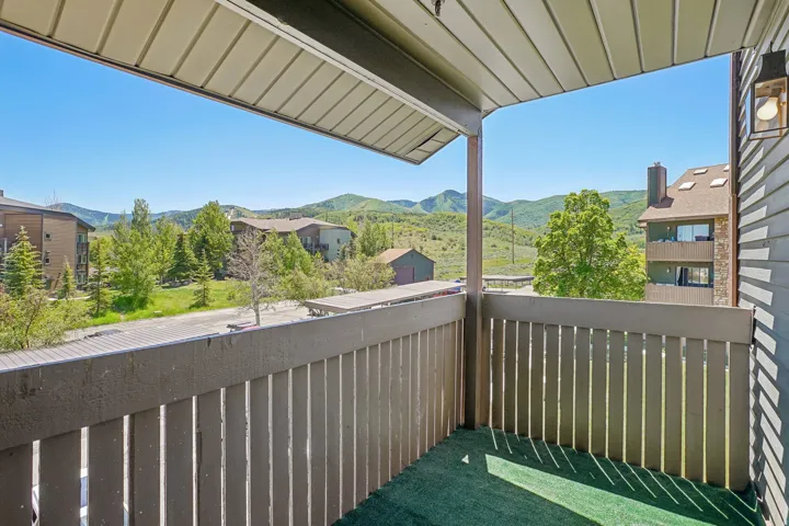 Private balcony with artificial turf flooring, offering a mountain backdrop and surrounding greenery
