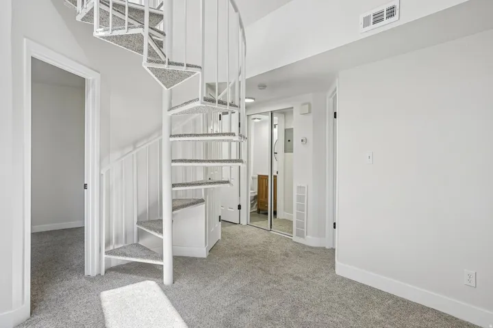 White spiral staircase with carpeted treads