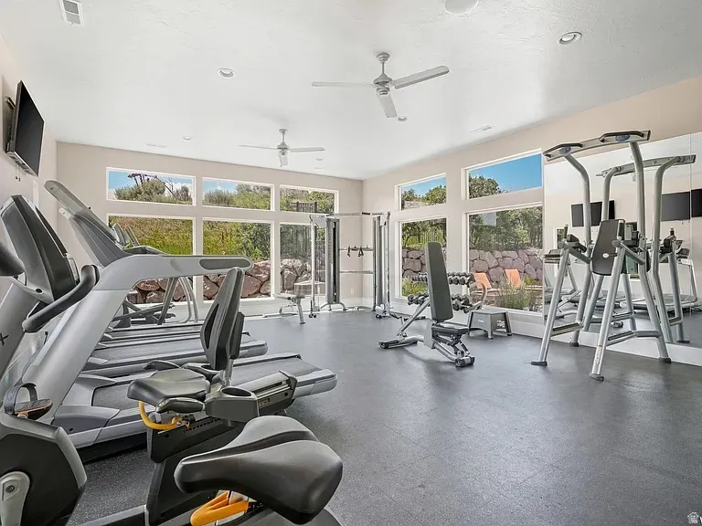 Fitness room featuring large picture windows, recessed lighting, ceiling fans, and a reflective mirrored wall