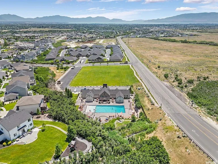 Aerial perspective showcasing a residential community with distant mountains and a body of water