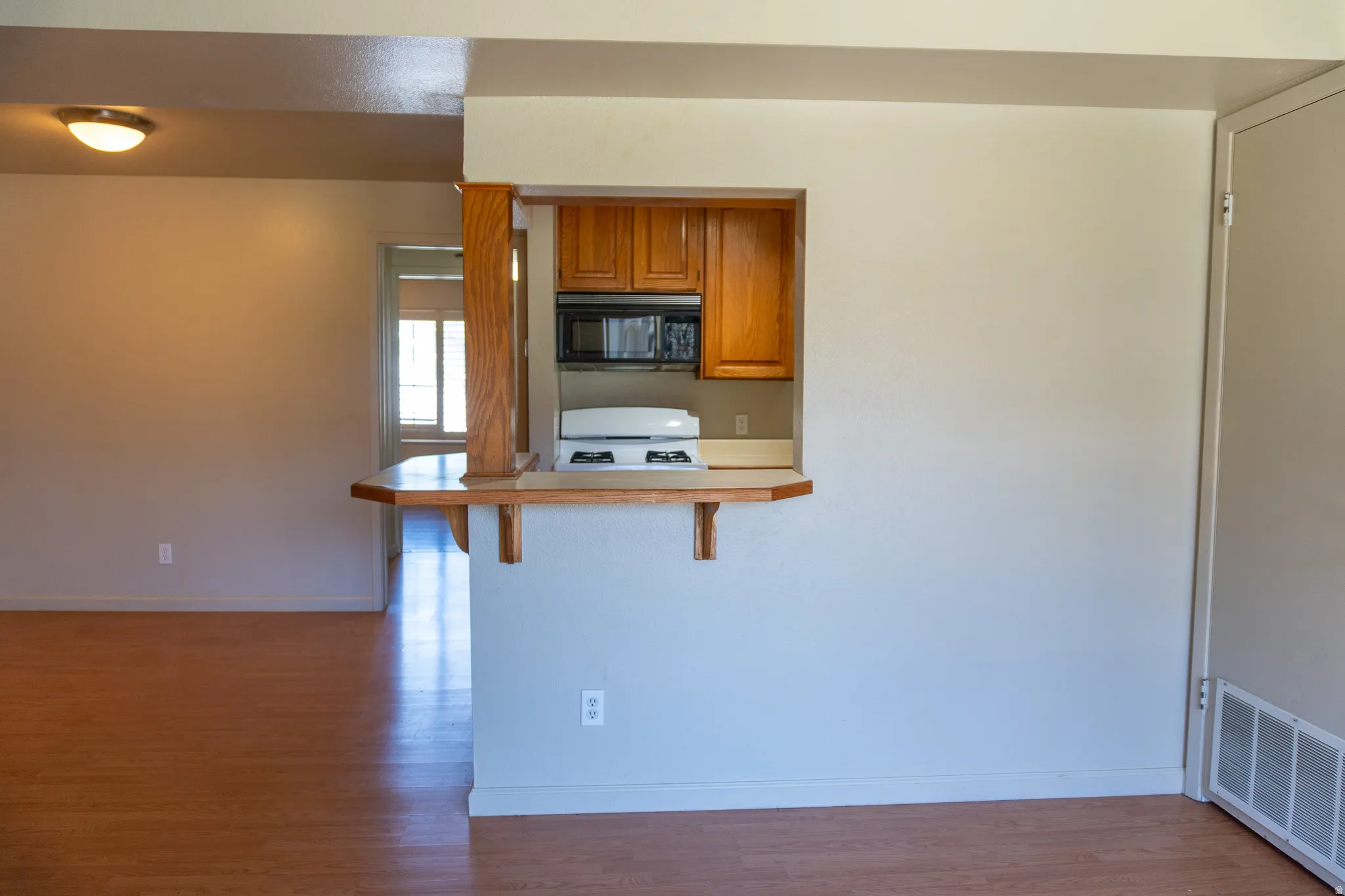 Kitchen pass-through window with wood trim and counter