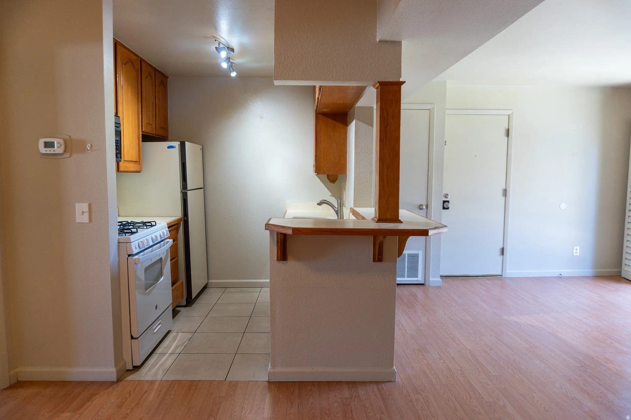 Kitchen with tile flooring and wood cabinetry