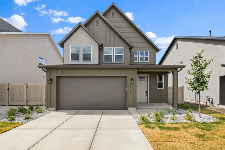 Contemporary two-story exterior with board and batten siding, attached two-car garage, covered front porch, and concrete driveway