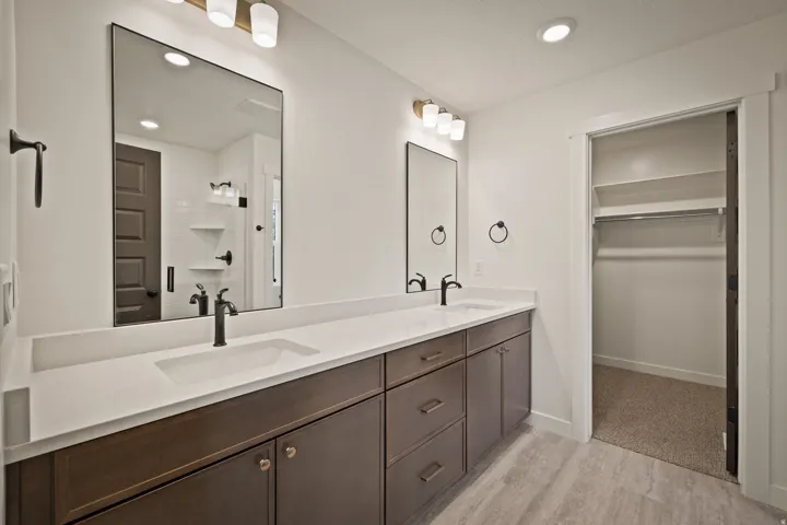 Dual vanity with integrated sinks, quartz-finish countertops, and dark-finish cabinetry