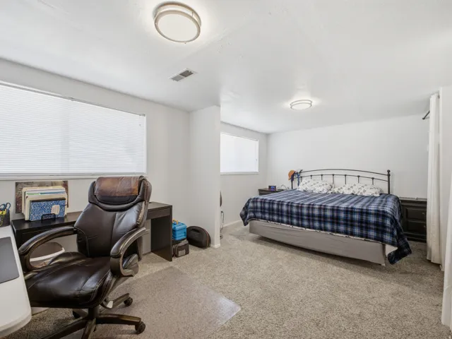 Carpeted room featuring dual windows, built-in overhead lighting, and white walls