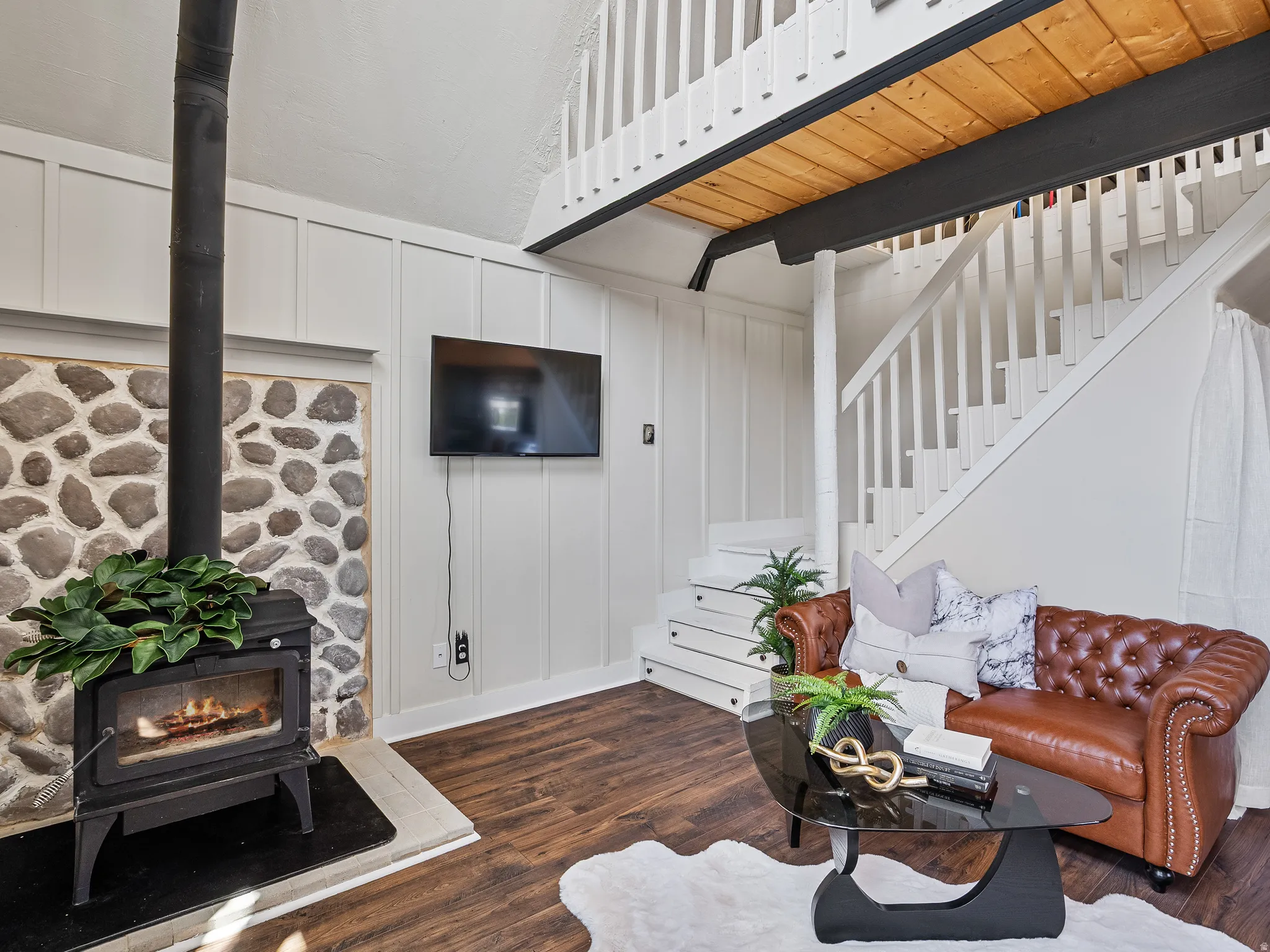 Living area featuring a stone accent wall, and a  wood burning stove.