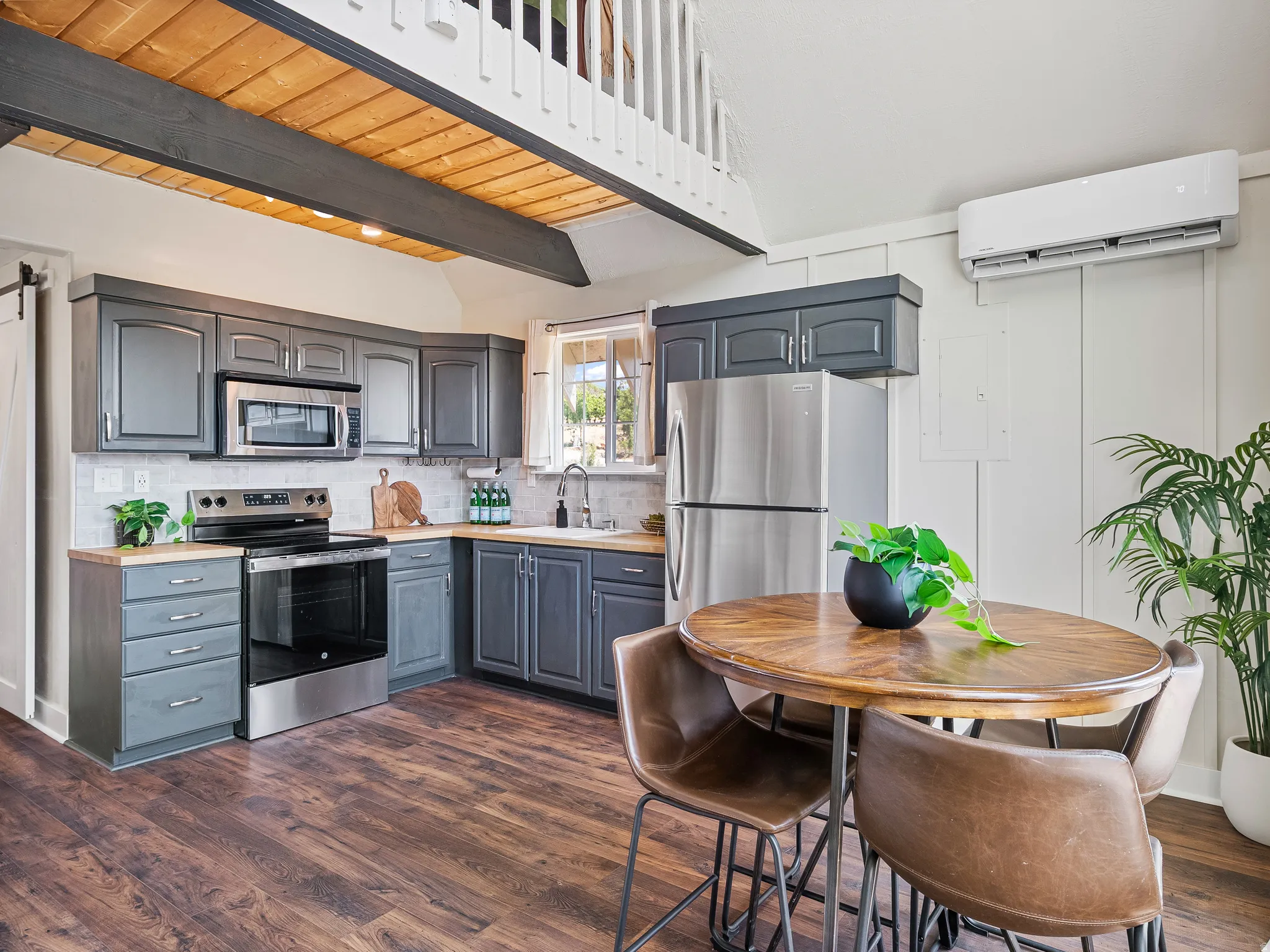 Kitchen, stainless steel appliances, a cream subway tile backsplash, and a wood countertop