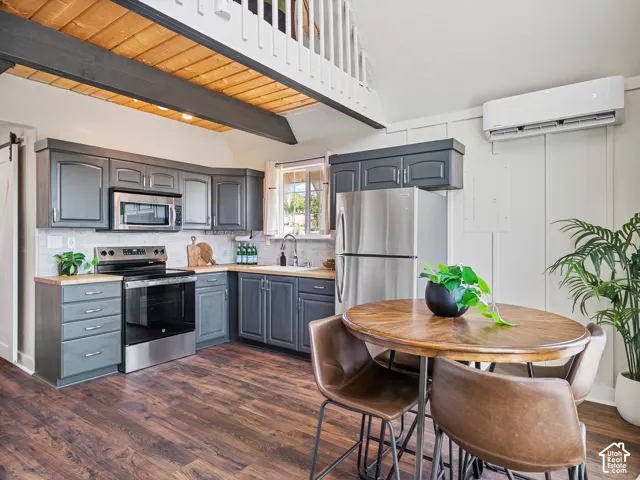 Kitchen, stainless steel appliances, a cream subway tile backsplash, and a wood countertop