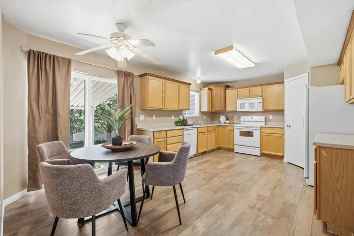 Open concept kitchen with wood-finish flooring and light-toned cabinetry
