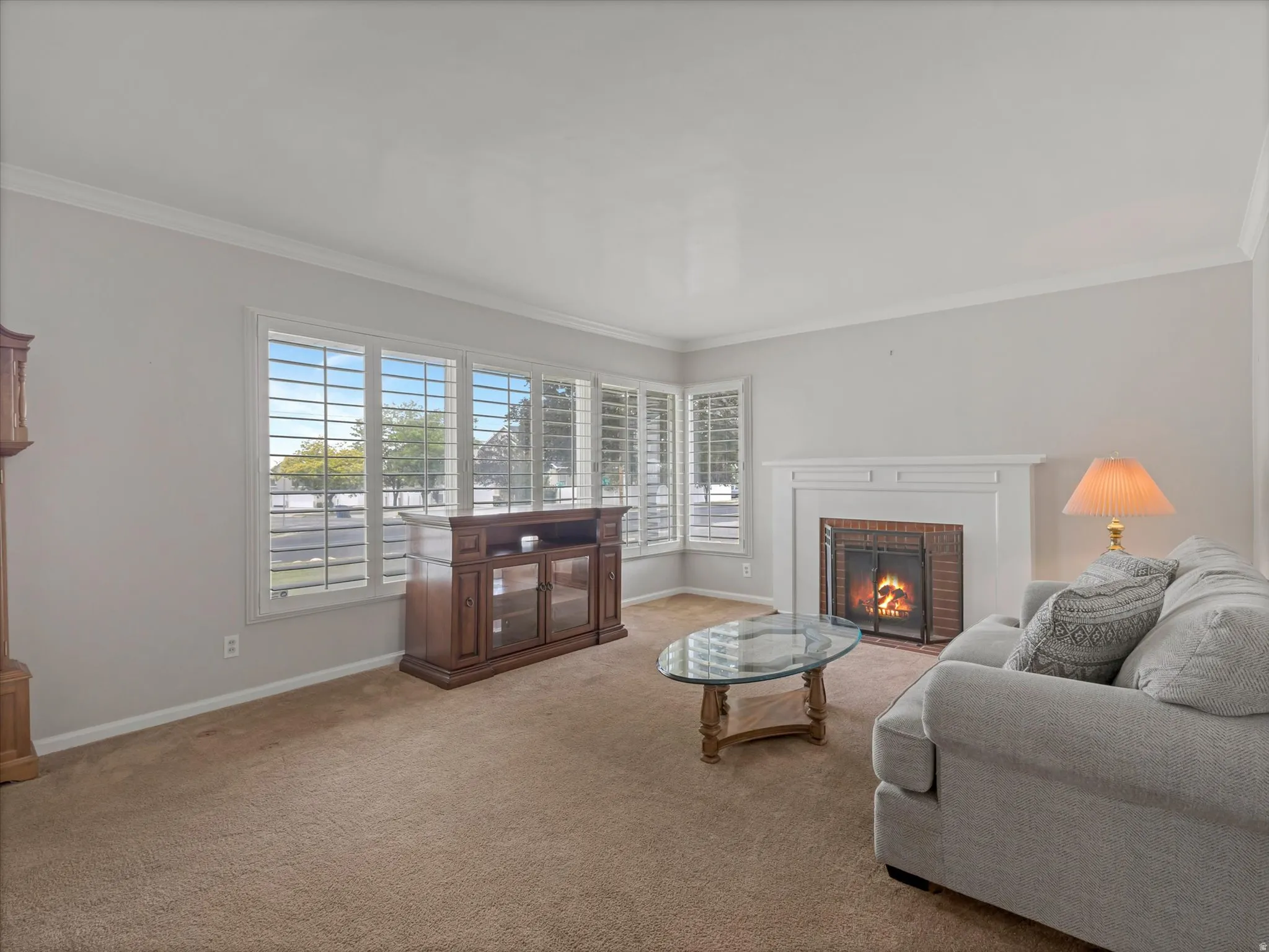 Living area with a fireplace featuring a white mantel and a brick hearth
