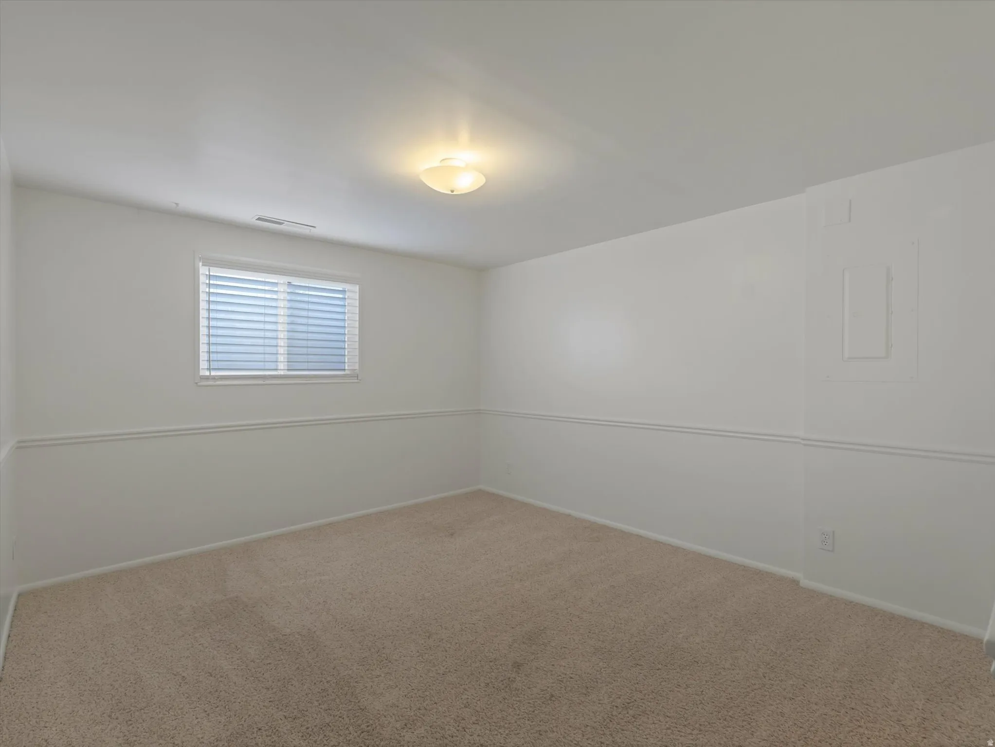 Neutral-toned carpeting paired with white walls and wainscoting