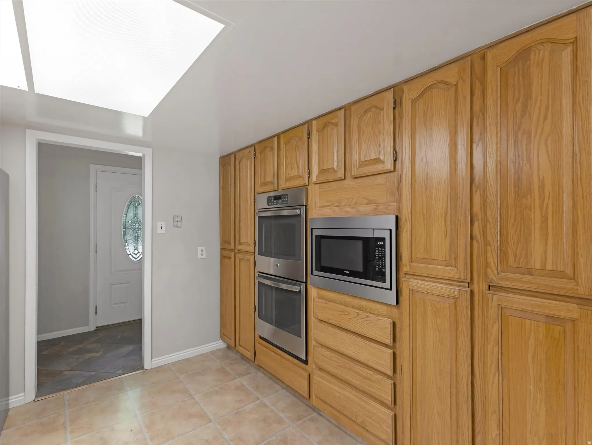 Kitchen featuring extensive wood cabinetry, built-in double ovens, and an integrated microwave