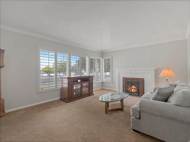 Living area with a fireplace featuring a white mantel and a brick hearth
