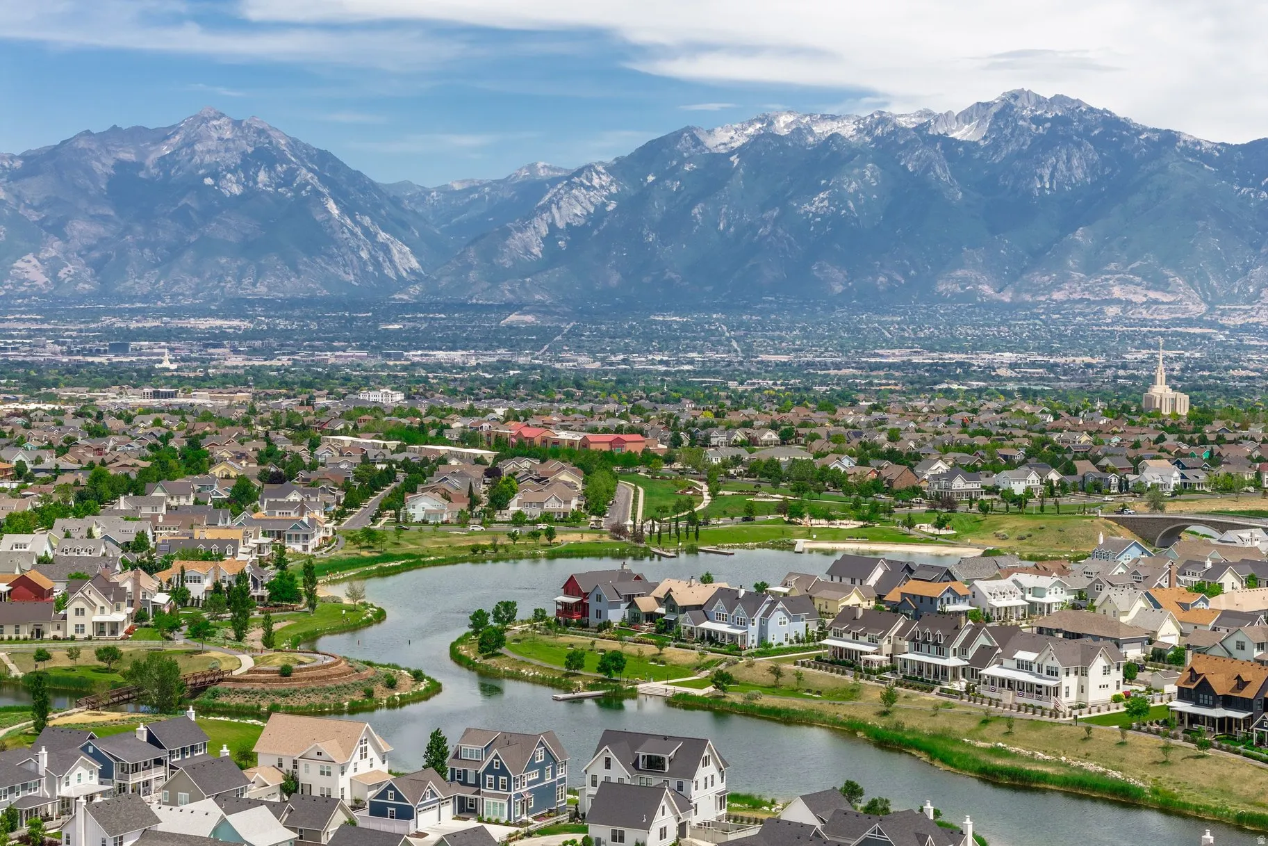 Expansive aerial perspective showcasing a residential community with a large central lake and surrounding green spaces