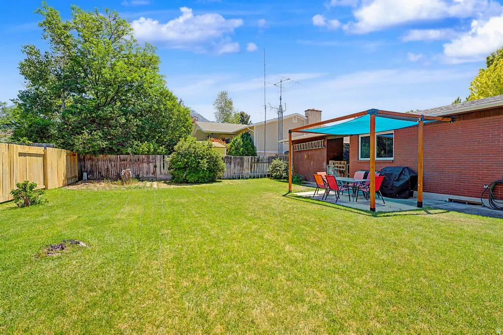 Yard with covered patio and brand new back fence