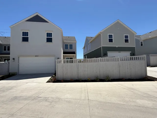 Contemporary architectural style featuring stucco and siding exteriors, attached garages, private fencing, and concrete driveways