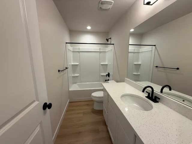 Bathroom featuring a white vanity with a speckled countertop, undermount sink, and matte black faucet