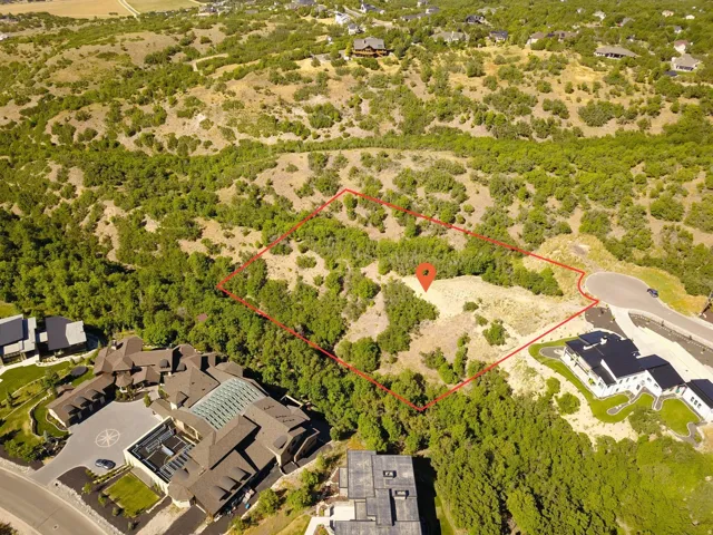 Expansive undeveloped lot featuring natural vegetation and a partial paved road boundary