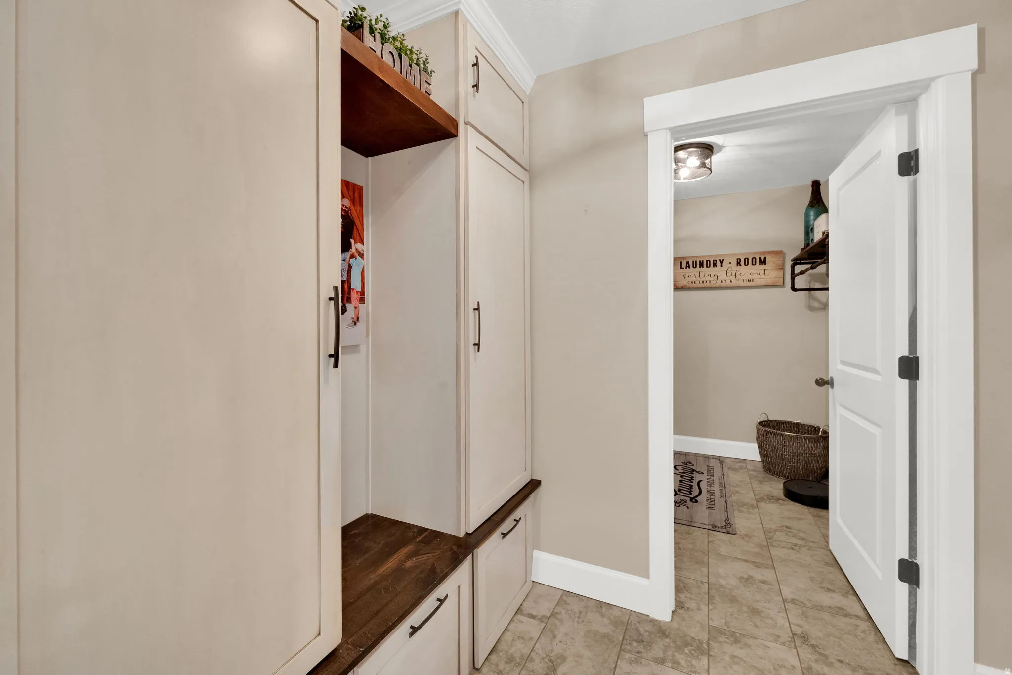 Built-in cabinetry with wood-finish seating and overhead storage, featuring white shaker-style doors and dark hardware