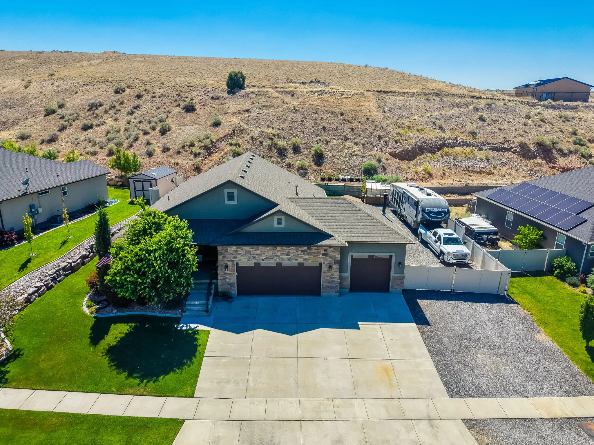 Single-story residence featuring a stone and stucco exterior, an attached two-car garage, and a separate single-car garage