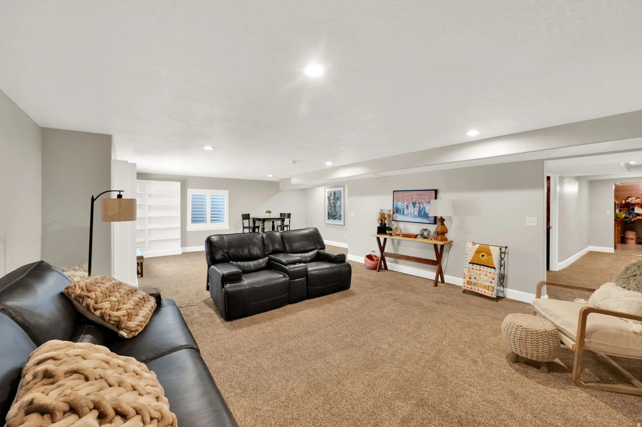 Expansive carpeted room with recessed lighting and neutral wall tones