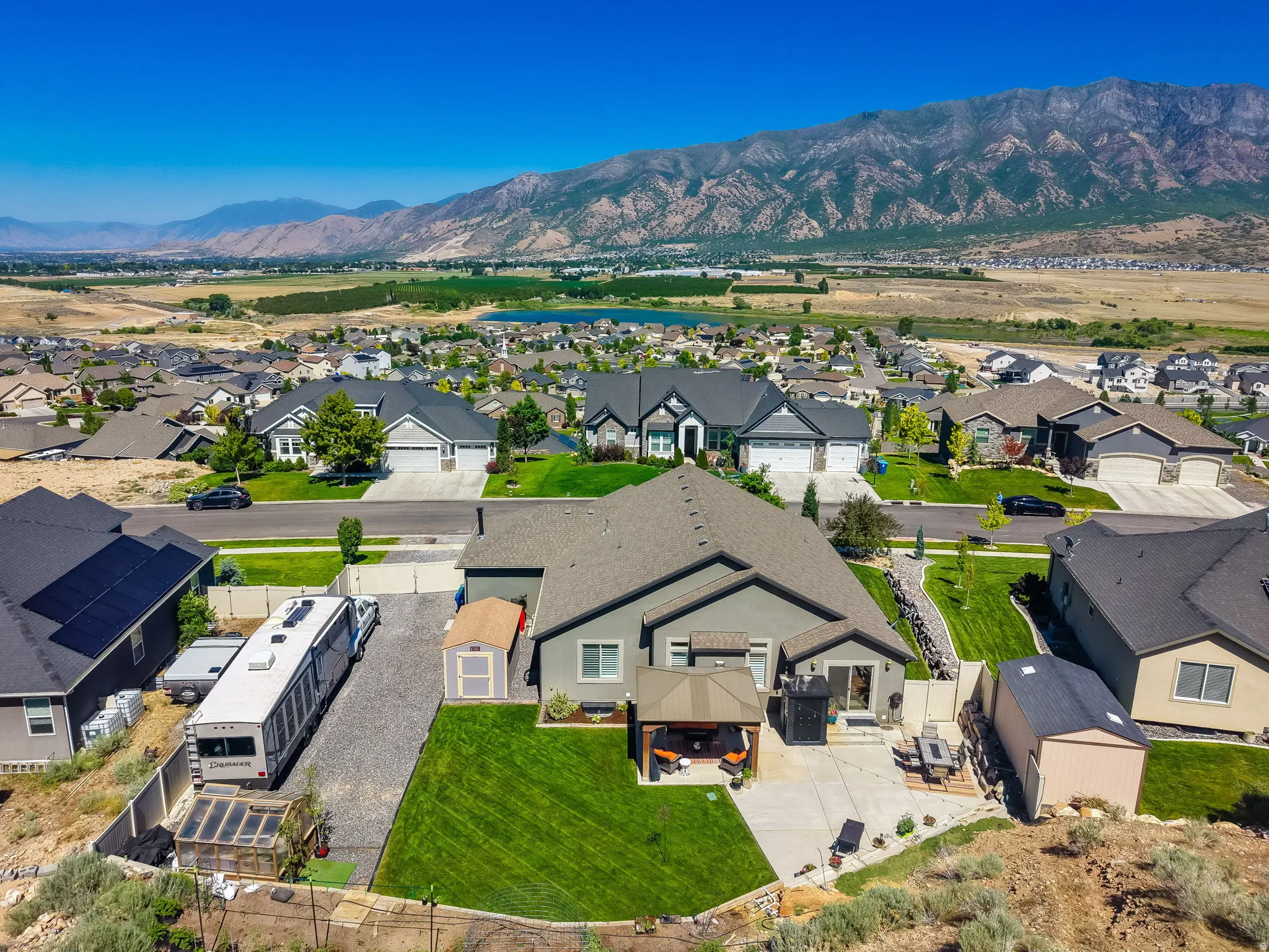 Aerial perspective showcasing a residential property with a panoramic mountain backdrop