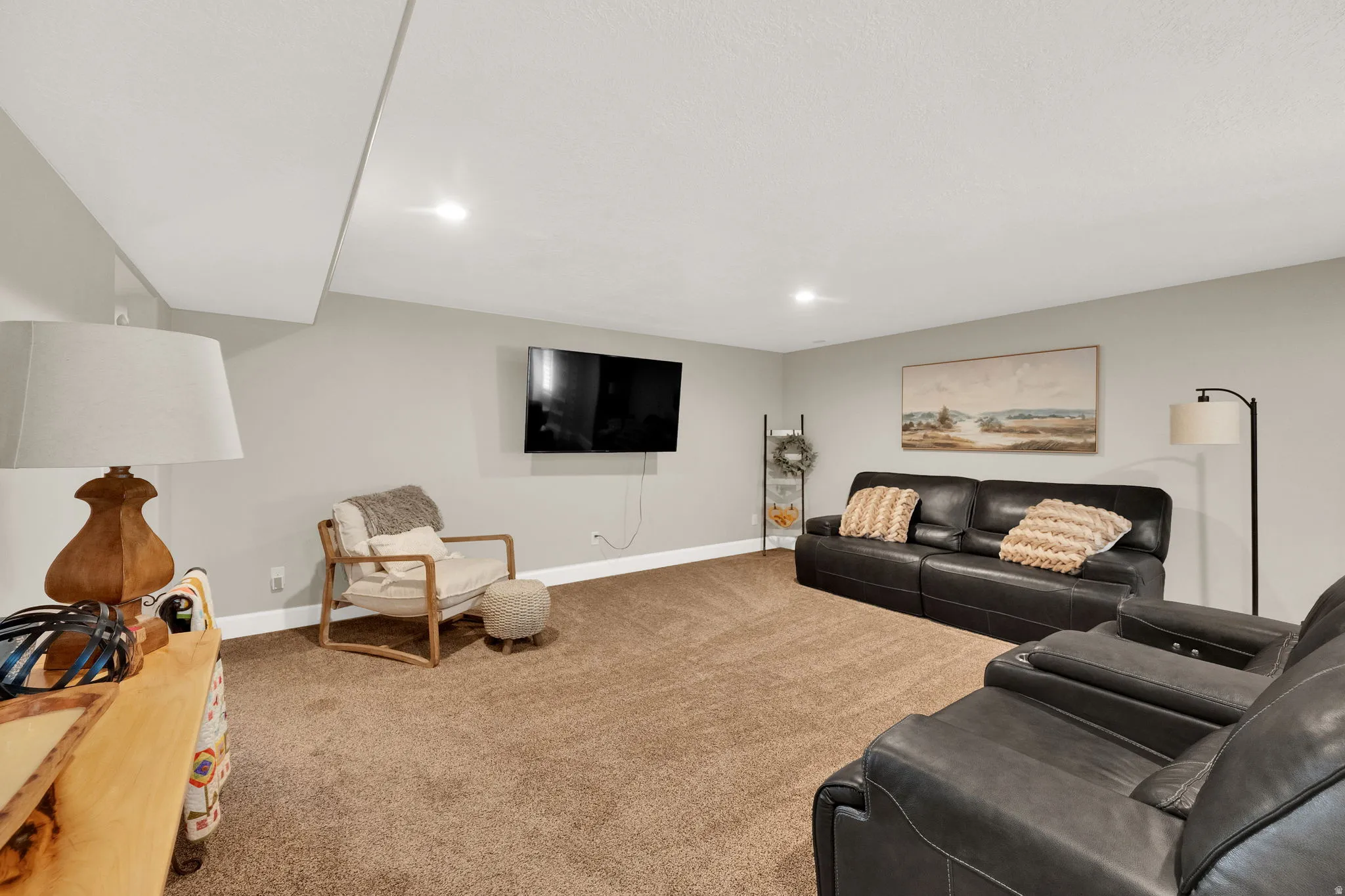 Spacious recreation area featuring neutral tone carpeting and light grey wall paint