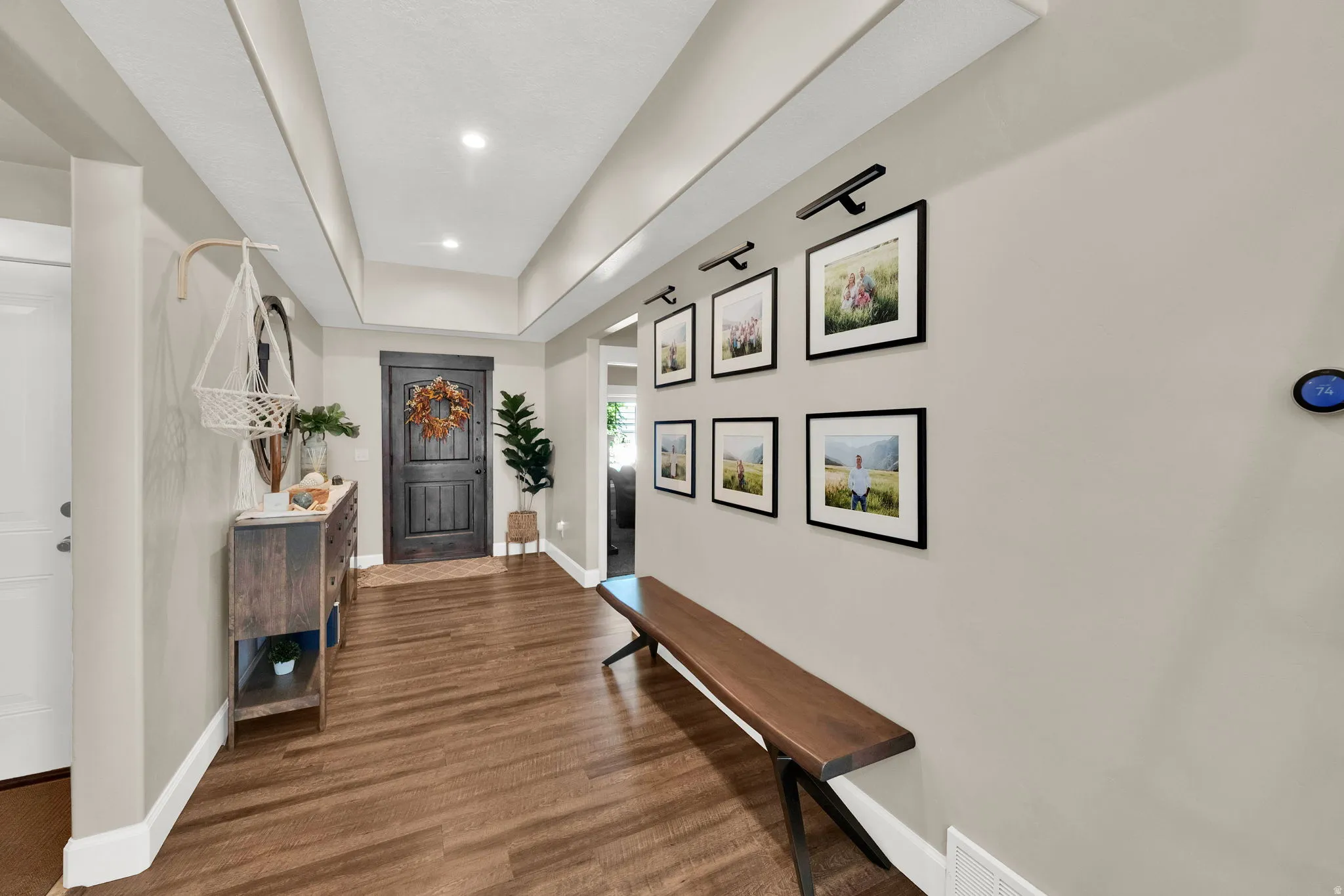 Inviting entry featuring wood-finish flooring, recessed lighting, and a dark-stained main door