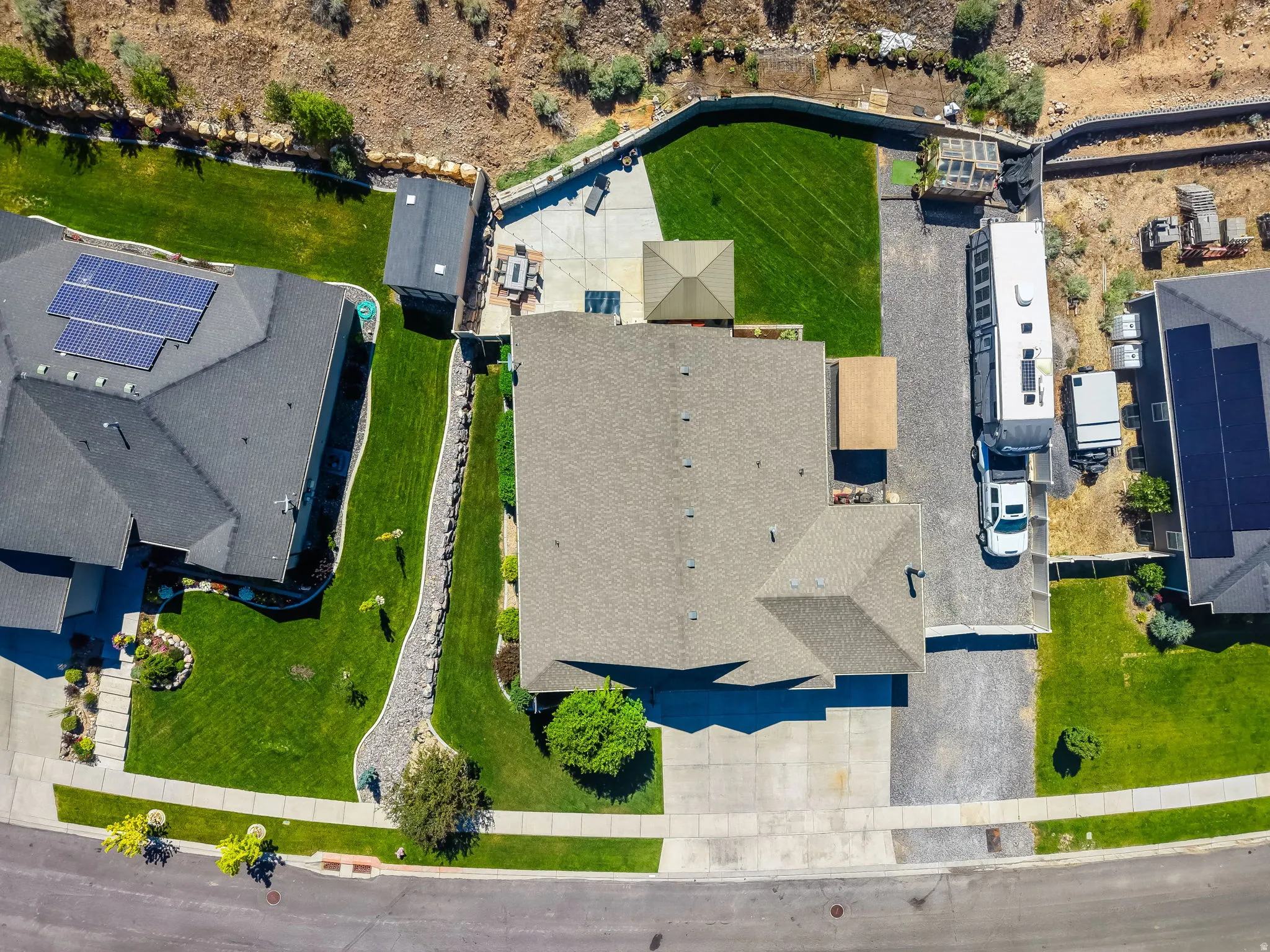 Property featuring a paved driveway, attached garage, and a gravel side parking area