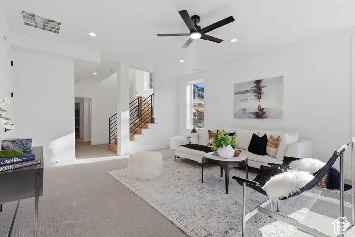Living area featuring recessed lighting and a black ceiling fan